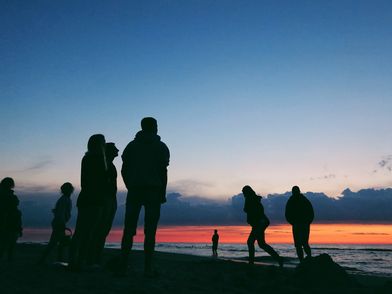 Menschen bei Sonnenuntergang am Strand