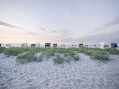 Strand mit Dünen und Strandkörben in Sonnenuntergangsstimmung