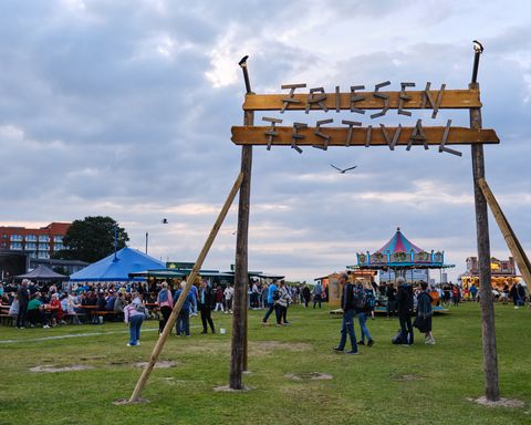 Eingangstor Friesenfestival mit Getränkestände und Karousel im Hintergrund
