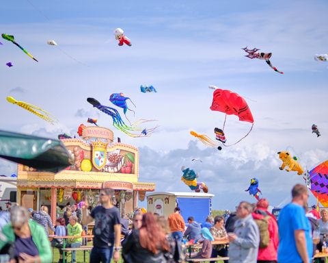 Drachen in der Luft über einem Festplatz 