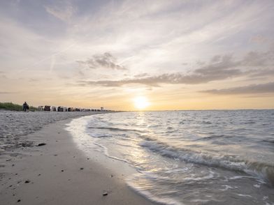 Sonnenuntergang am Strand mit Wasserkante im Vordergrund