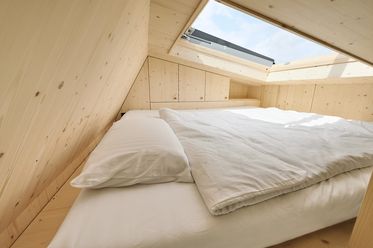 Bett unterm Dach mit großem Dachfenster im Green Tiny House 