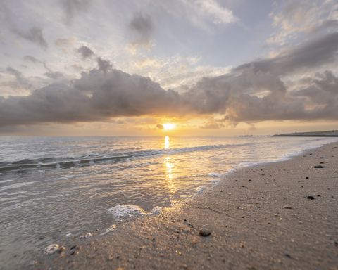Nahaufnahme von Wellen am Strand im Sonnenuntergang