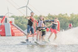 Vier Personen auf Wakeboards, die in einer Gruppe fahren