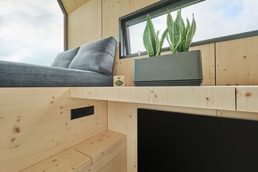 Pflanze und gemütliche Sitzecke im Green Tiny House