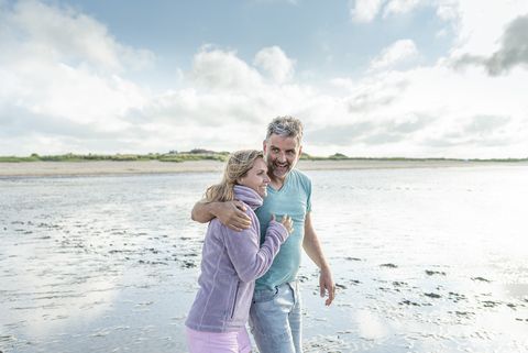 Ein Pärchen läuft Arm in Arm durchs Watt