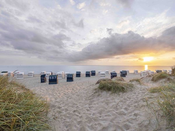 Sonnenuntergang am Strand mit Dünen und Strandkörben