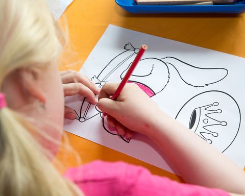 Blick über die Schulter eines Mädchens, dass ein Ausmalbild ausmalt